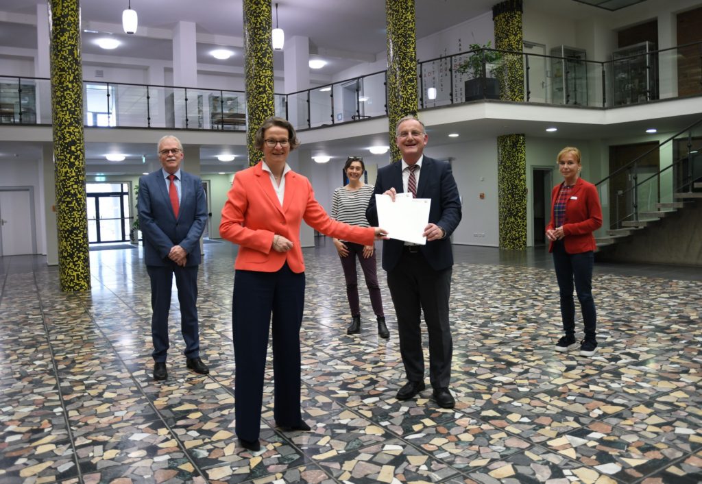 Foto: (v.l.n.r.) Erhard Vanselow, Ministerin Ina Scharrenbach, Dr. Inken Tintemann, Bürger-meister Paul Larue und Christine Käuffer bei der Übergabe der Zuwendungsbescheide im Rathausfoyer.