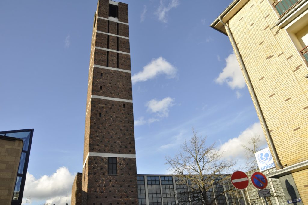 Der Turm der Annakirche flankiet von zwei Hausfassaden