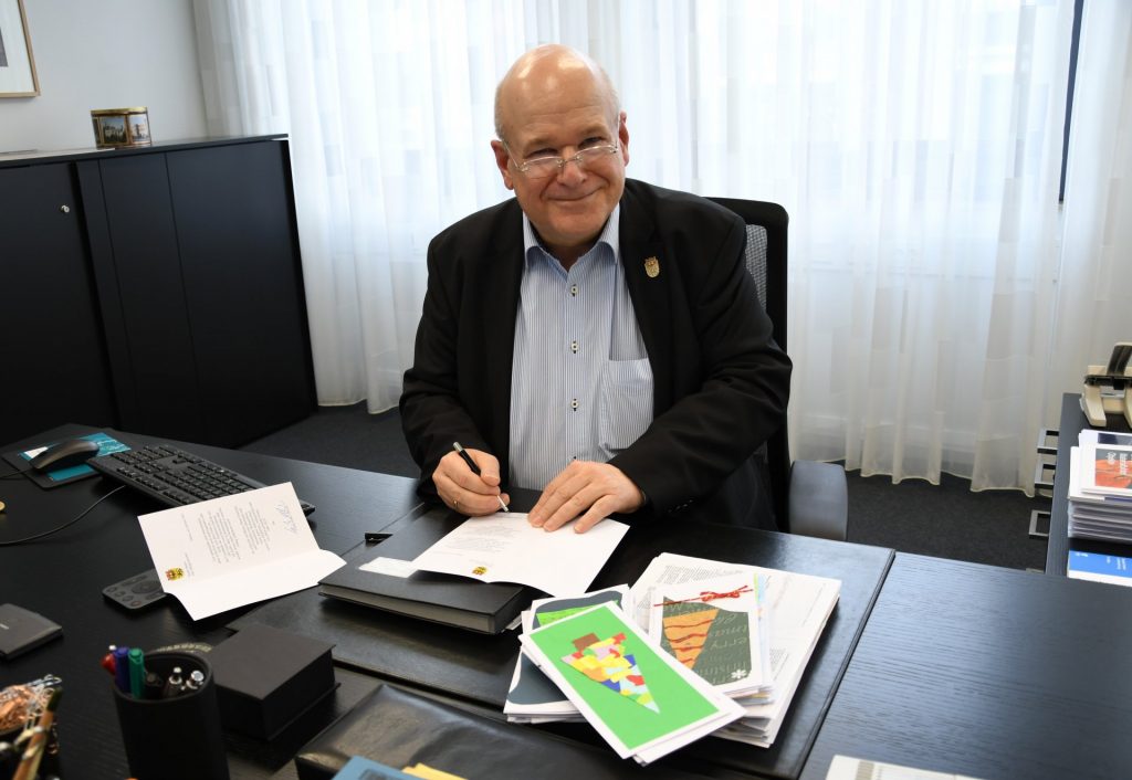 Bürgermeister Frank Peter Ullrich bei der Unterzeichnung der Weihnachtspostkarten.