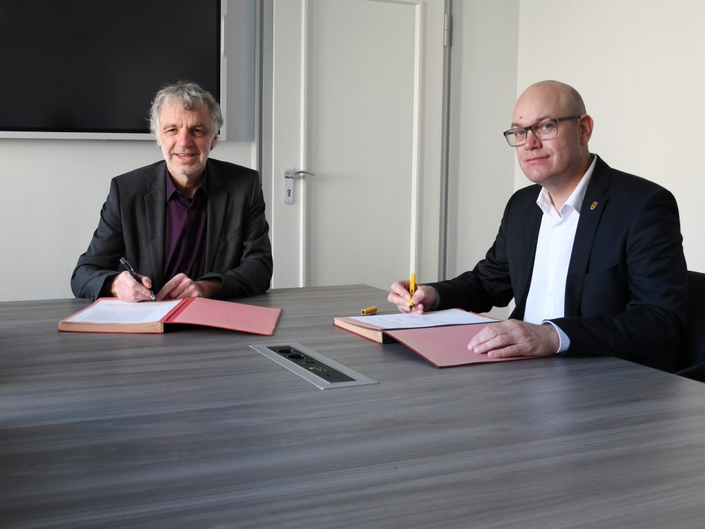 Ralf Ostermann von FischerTeamplan (l.) und Niels-Christian Schaffert, Technischer Beigeordneter der Stadt Düren, unterzeichnen den Planungsvertrag für das südliche Planungsgebiet