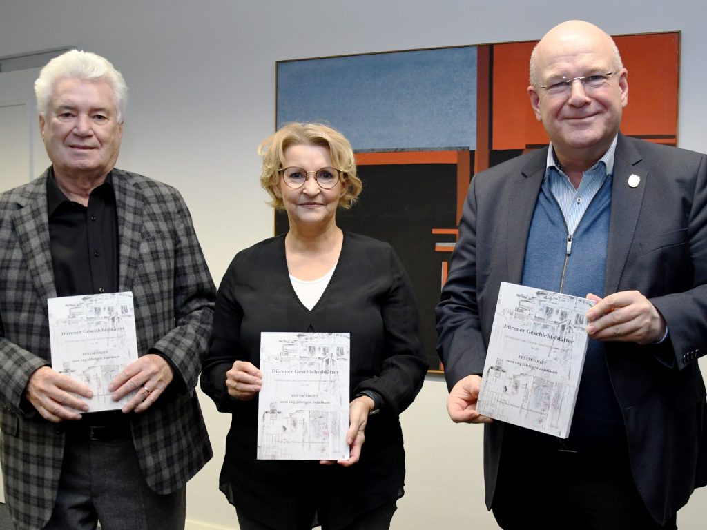 (v.l.n.r.): Der erste Vorsitzende, Dr. Helmut Irmen, und die Geschäftsführerin des Dürener Geschichtsvereins, Claudia Latotzki, haben im Rathaus die 89. Ausgabe der Dürener Geschichtsblätter vorgestellt und ein Exemplar an Bürgermeister Frank Peter Ullric