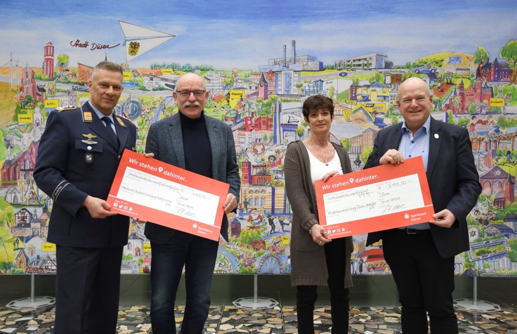 (v.l.n.r.) Oberst Timo Heimbach, Peter Kaptain, Monika Leßenich und Bürgermeister Frank Peter Ullrich bei der symbolischen Scheckübergabe im Dürener Rathaus.