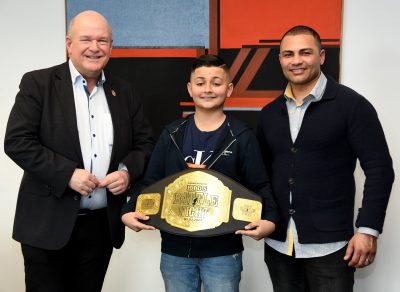 Zusammen mit seinem Vater Baktash Saidi (r.) präsentiert Rayan Saidi bei einem Empfang im Rathaus Bürgermeister Frank Peter Ullrich (l.) stolz seinen Sieger-Gürtel.