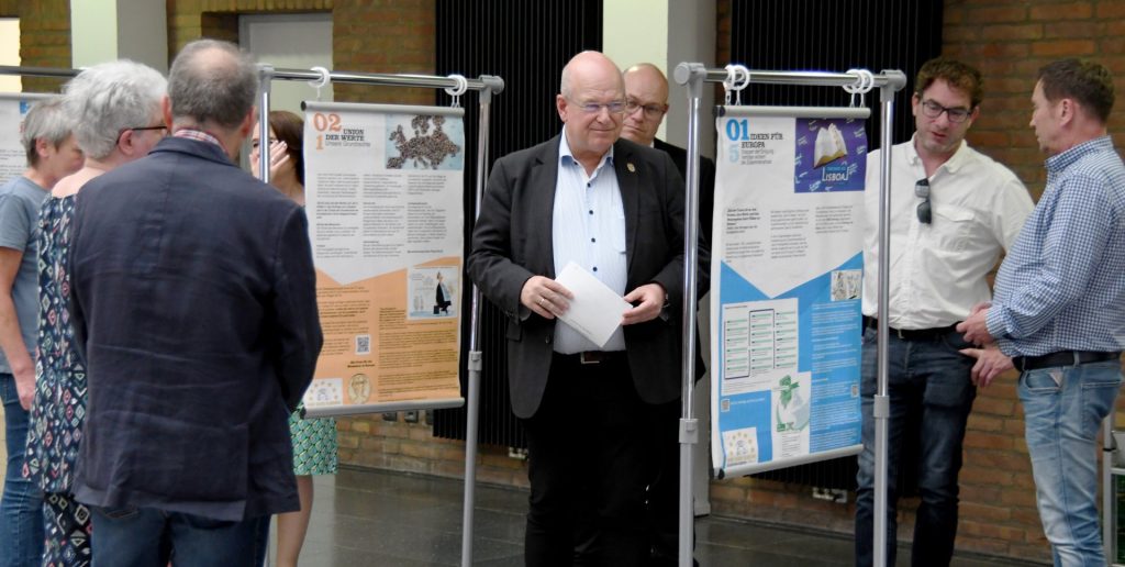 Bürgermeister Frank Peter Ullrich und die Präsidentin des Europavereins GPB zusammen mit weiteren Besuchern bei der Ausstellungseröffung im Rathaus.