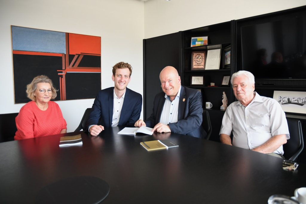 Gruppenfoto am Tisch mit vorliegendem Buch