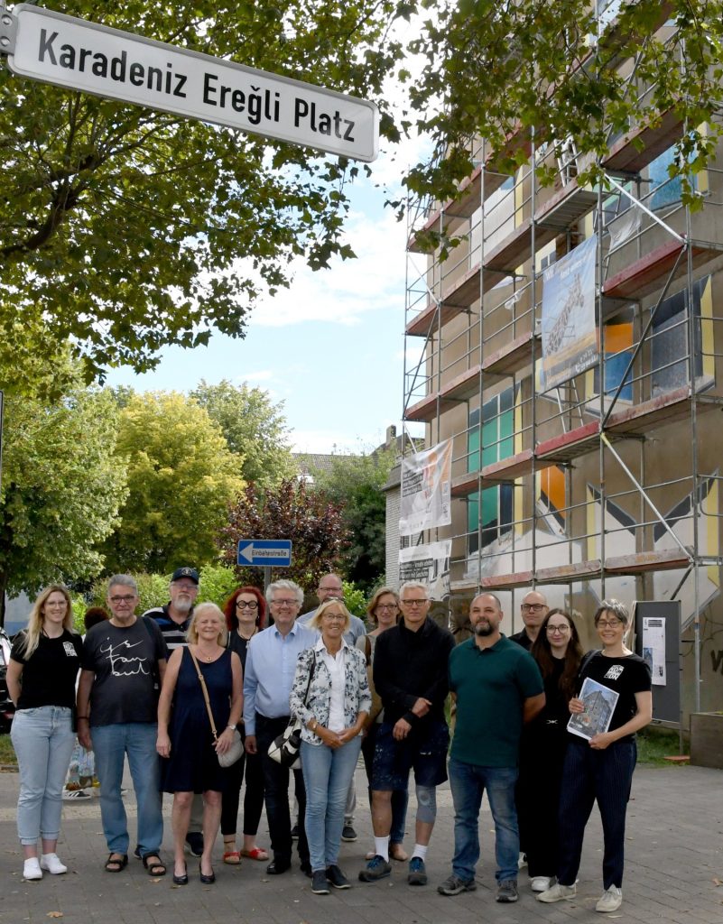 eine Gruppe Menschen vor einer Hausfassade