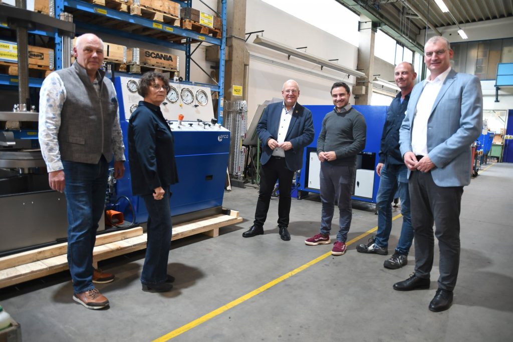 Gruppnefoto vor einer Werkmaschine