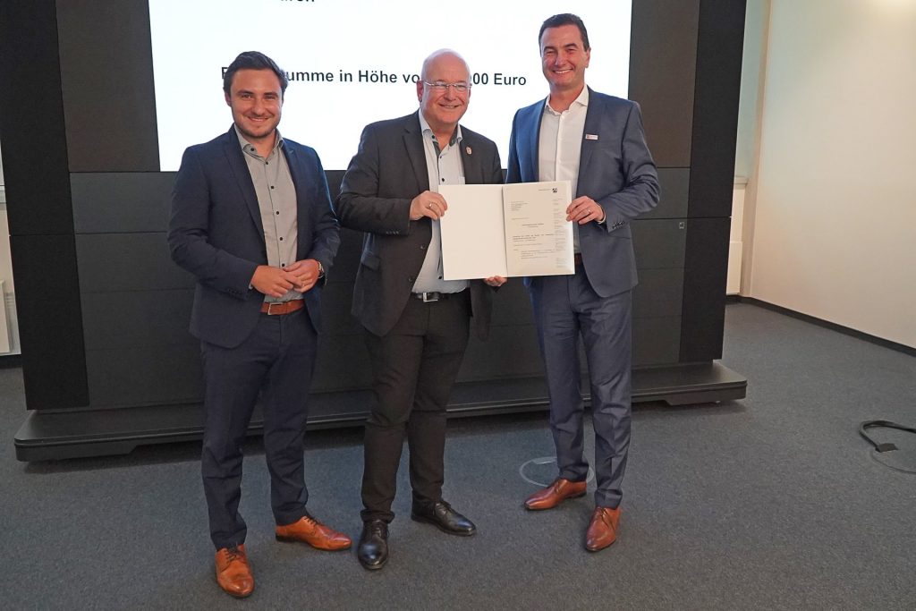 Gruppenfoto mit dem persönlichen Referenten, Sebastian Eich, Bürgermeister Frank Peter Ullrich und Regierungspräsident Dr. Thomas Wilk, der den Förderbescheid übergibt.