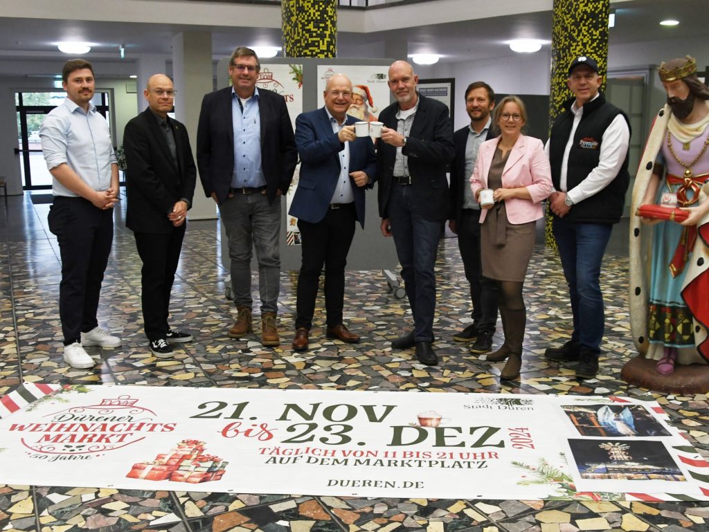 Gruppenfoto im Rathausfoyer. Im Vordergrund das Veranstaltungstransparent