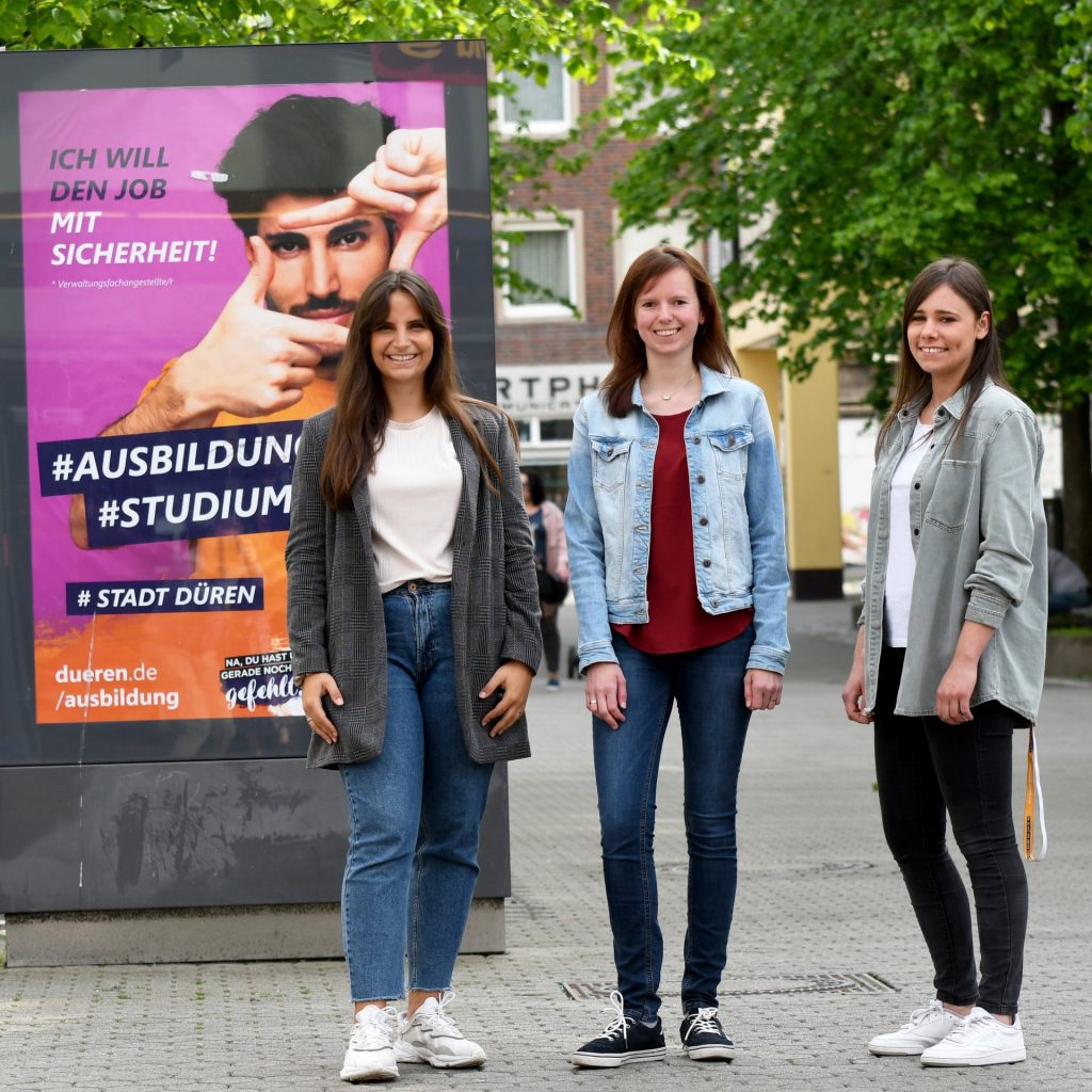 Gruppenbild mit Menschen vor einem Schild in der Dürener Innenstadt