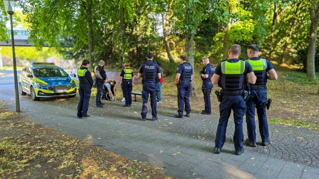 Personen von Polizei und Ordnungsamt in einer Dürener Parkanlage