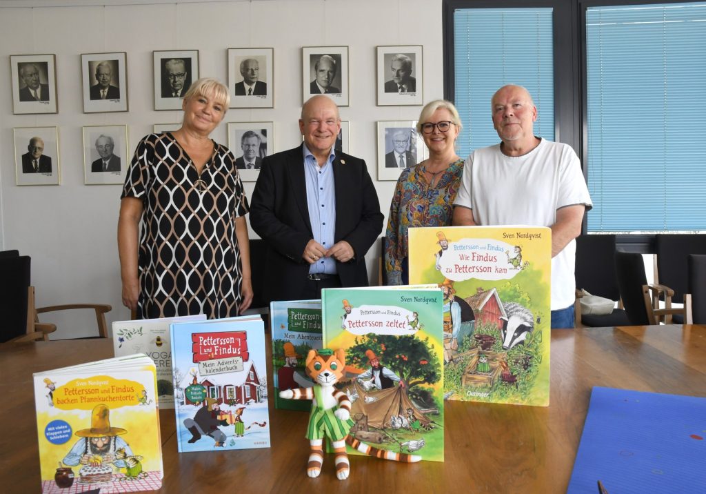 Gruppenfoto. Auf einem Tisch stehen Bücher aus der Buchserie