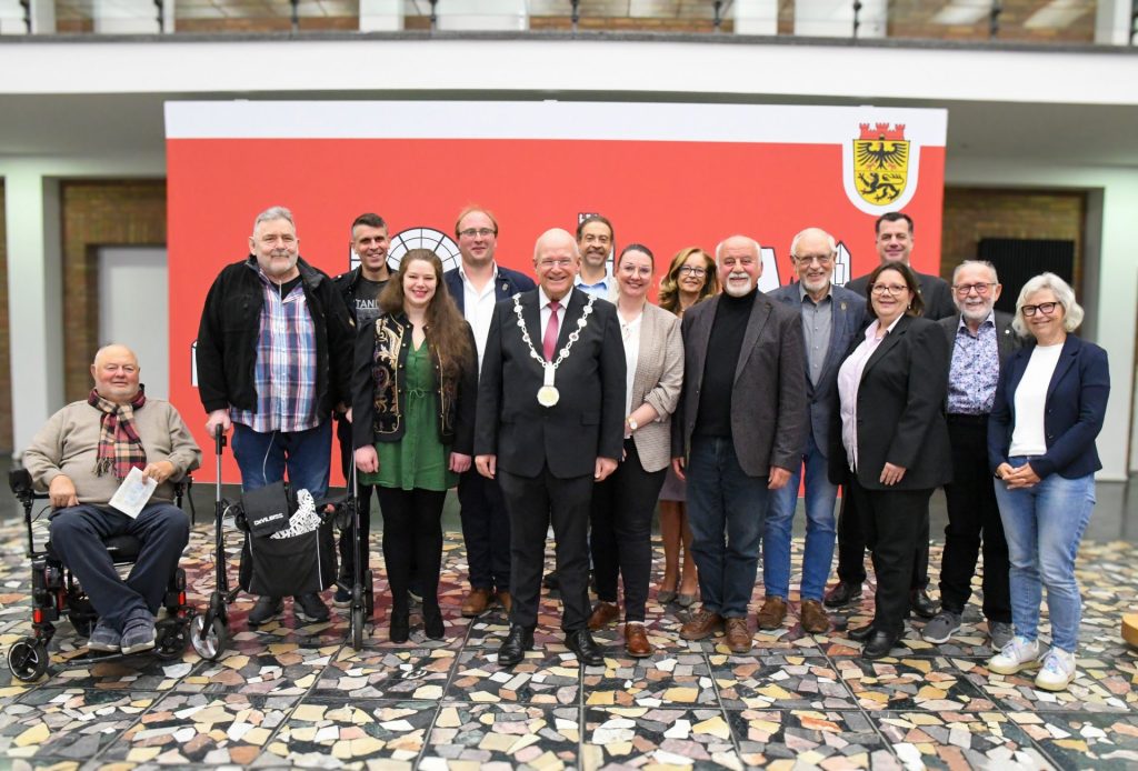 Gruppenfoto im Rathausfoyer zur offiziellen Verabschiedung von Ratsmitgliedern. Im Hintergrund die Skyline von Düren.