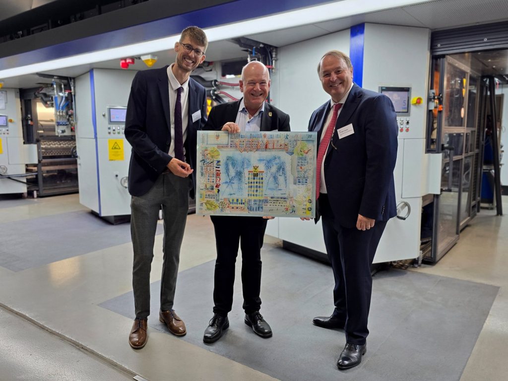 Menschen vor einer Maschine in einer Fabrikhalle
