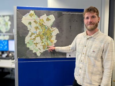 Ein Mann steht vor einem Stadtplan, der an einer Pinwand aufgehängt ist