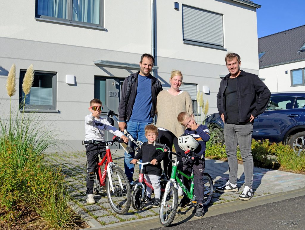 Foto der Familie vor ihrem Haus.