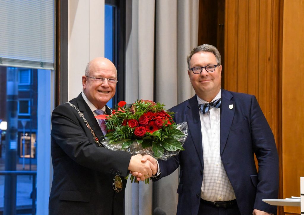 Stefan Weschke überreicht im Ratssaal einen Blumenstrauß an Bürgermeister Frank Peter Ullrich.