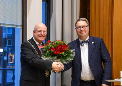 Stefan Weschke überreicht im Ratssaal einen Blumenstrauß an Bürgermeister Frank Peter Ullrich.
