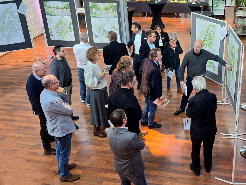 Mehrere Menschen stehen vor Stellwänden mit architektonischen Plänen