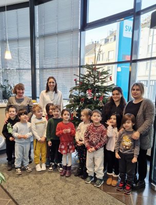 Gruppenbild mit Menschen vor einem Weihnachtsbaum