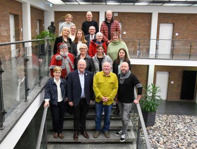 Gruppenfoto mit Bürgermeister, Spendern und Empfängern auf der Treppe im Rathausfoyer.