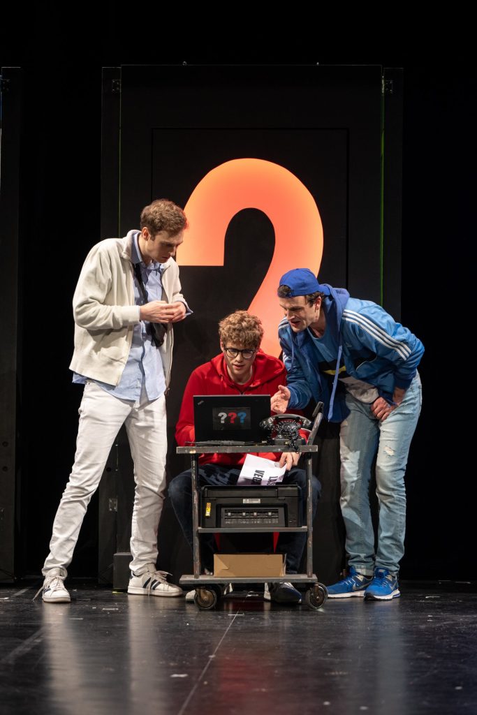 Drei Menschen auf einer Theaterbühne