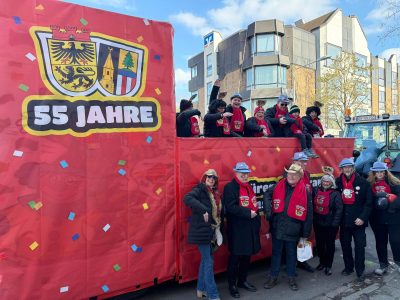 Menschen vor und auf einem Karnevalszug