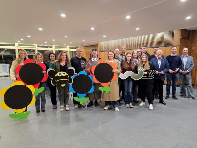 Viele Menschen sitzen an mehreren Tischen