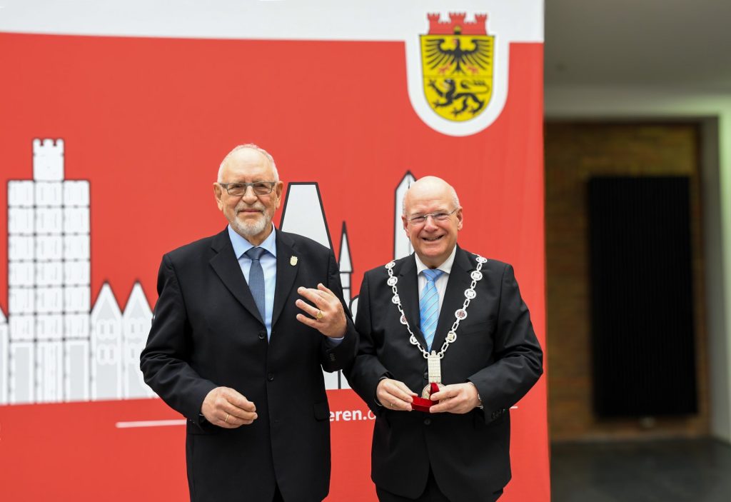 Stolz präsentiert der neue Ehrenringpreisträger Peter Koschorreck seine Auszeichnung. Rechts: Bürgermeister Frank Peter Ullrich
