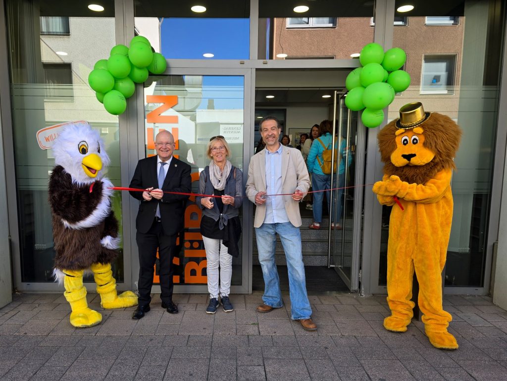 Gruppenbild mit Menschen, die ein rotes Band durchschneiden