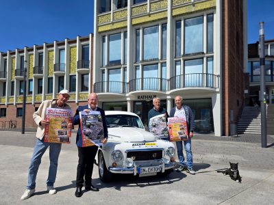 Gruppenbild mit Menschen und Oldtimer