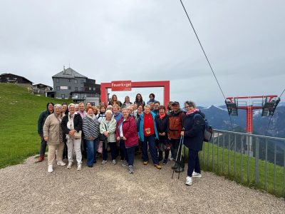 Gruppenbild mit Menschen und Bergpanorama