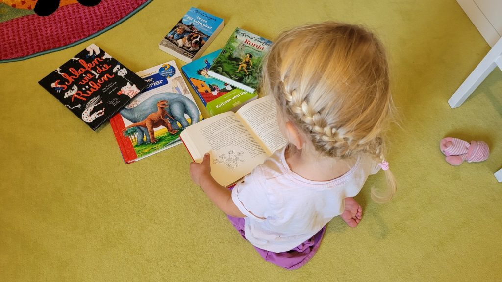 Ein Kind sitzt vor Büchern