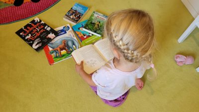 Ein Kind sitzt vor Büchern