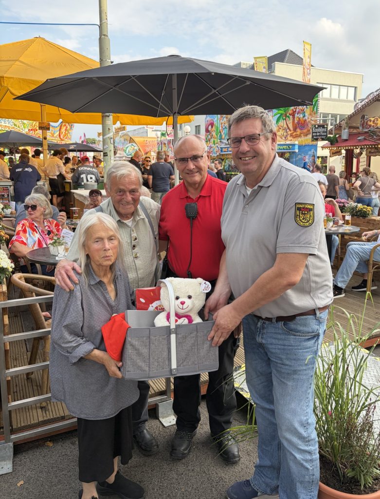Das Foto zeigt Beppo und Anita Felten bei der Übergabe des Abschiedsgeschenks durch Frank Blument-hal und Platzmeister Achim Greiff auf der Dürener Annakirmes.